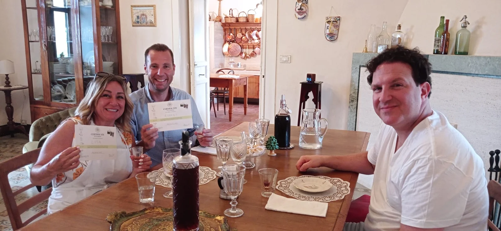 Ospiti a tavola mostrano i loro attestati dopo la cooking class