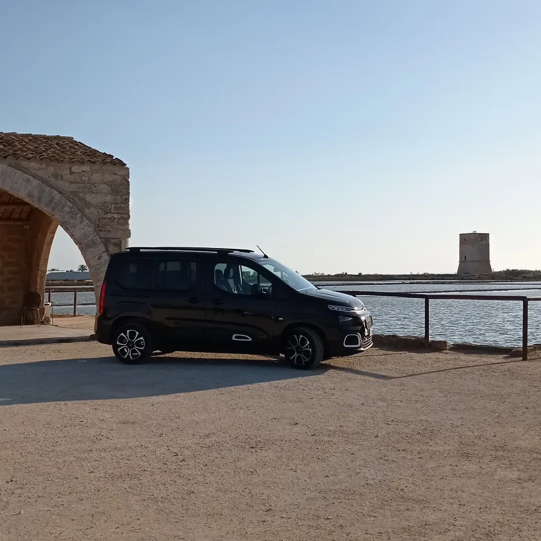 Il van di Nonna Giò accanto a un edificio in pietra sul mare